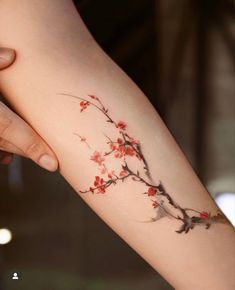 a woman's arm with red flowers on it