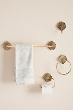 a towel rack with two towels hanging from it's sides and three rings on the wall