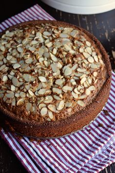 a chocolate cake with almonds sitting on top of a red and white towel