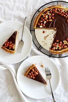 two white plates with slices of pie on them and one slice has chocolate frosted almonds