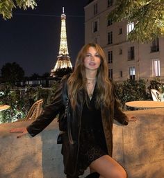 a woman posing in front of the eiffel tower