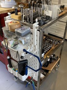 a metal cart filled with lots of tools and other items on top of a table