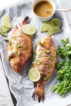 two fish fillets with limes and cilantro garnish