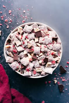 a bowl filled with chocolate and marshmallows on top of a blue surface