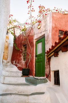 a green door on the side of a building with steps leading up to it's entrance