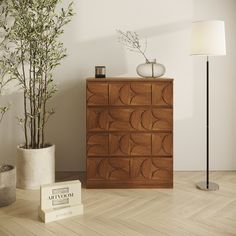 a wooden dresser sitting next to a lamp on top of a hard wood floor