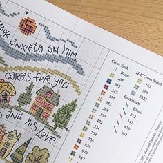 a cross stitch book on a table with the words, numbers and symbols in it