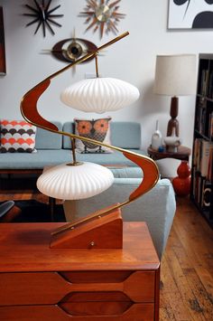 a living room filled with furniture and a lamp on top of a wooden table in front of a blue couch