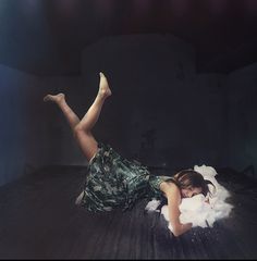 a woman laying on top of a wooden floor