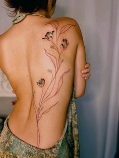 the back of a woman's body with flowers on her upper and lower back