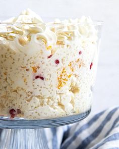 a cake with white frosting and cranberries in a glass dish