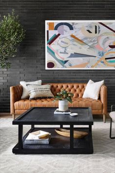 a living room with two couches and a coffee table in front of a painting