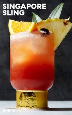 a close up of a drink in a glass with fruit on the rim and text that reads singapore sling