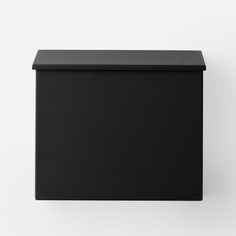 an empty black box sitting on top of a white wall