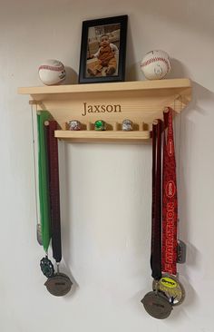 a wooden shelf with medals and baseballs on it