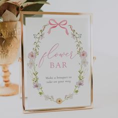 a flower bar sign sitting on top of a table next to a vase with flowers