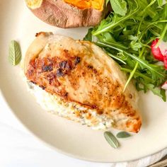 a white plate topped with meat and veggies next to a baked sweet potato