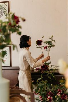 a woman arranging flowers in a room