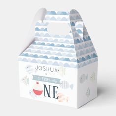 a white box with blue and green designs on the lid that says, joshua fish in one