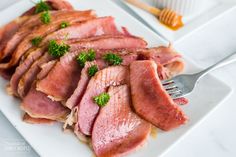 ham slices on a white plate with sauce and honey