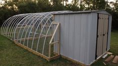 a small metal building sitting in the middle of a field