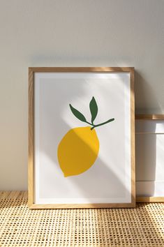 a yellow lemon on a white background in a wooden frame with shadow from the wall