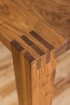 a close up of a wooden bench on a hard wood flooring area with no one around it