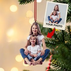 an ornament hanging from a christmas tree with a photo on it