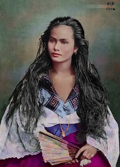 a woman with long black hair wearing a purple dress and holding several small cards in her hands