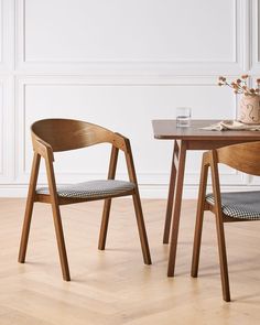 two wooden chairs sitting next to each other on top of a hard wood floored floor