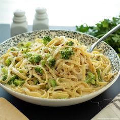 a white bowl filled with pasta and broccoli