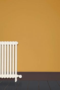 a white radiator sitting on top of a hard wood floor next to a wall