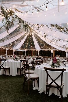 a large tent with tables and chairs under it