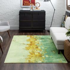 a living room filled with furniture and a rug on top of a hard wood floor