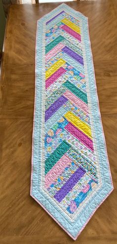 a quilted table runner sitting on top of a wooden table