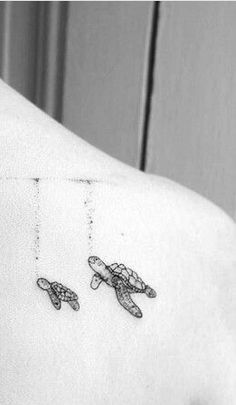 two small turtles on the back of a woman's shoulder