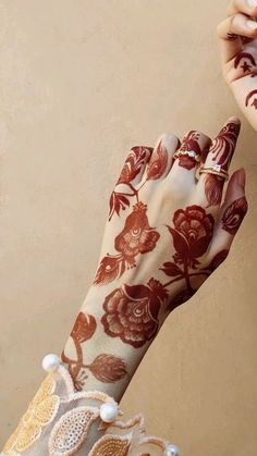 a woman's hand with henna on it and flowers painted on the wrist