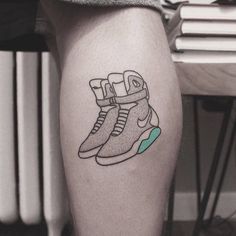 a person with a tattoo on their leg that has a pair of sneakers on it