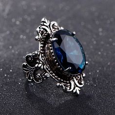 This gorgeous sterling silver ring is perfect for a person with a flare for vintage jewelry. The Blue Sapphire Peacock Vintage Ring features an oval blue sapphire as its centerpiece, encircled by small round white diamonds that catch the light gloriously and radiate life! From cornflower blue to velvety blue, there are multifarious shades of blue sapphire that gives it a silky tint. Characterized by the power of Shani or Saturn, Blue Sapphire displays violet to indigo and pale blue as well as da Sapphire Silver Ring, Pattern Ring, Men Vintage, Blue Sapphire Rings, 925 Jewelry, Rings For Women, Blue Rings, Topaz Ring, Ring Vintage