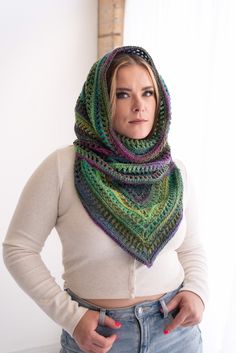 a woman is wearing a multicolored shawl