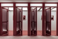 an empty room with red doors and pink flooring on the walls is pictured in this image