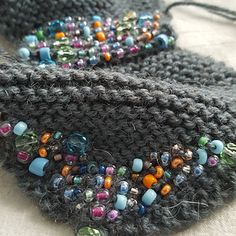 two crocheted purses with beads on them sitting on top of a table