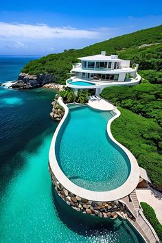 an aerial view of a house and pool in the ocean