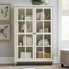 a white bookcase with glass doors in a living room