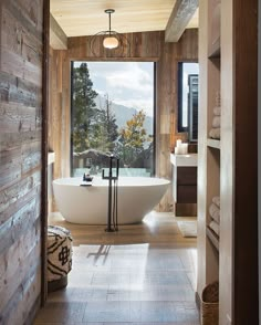 a bathroom with a large tub and wooden walls