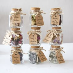 four jars filled with different types of spices and herbs, labeled with labels on them