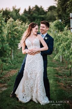 a bride and groom hugging in the vineyard