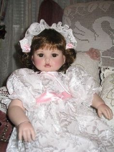 a doll is sitting on a chair in a white dress