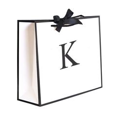 a black and white paper bag with the letter k on it's front side