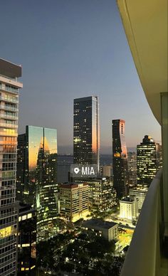 the city skyline is lit up at night, with skyscrapers in the foreground